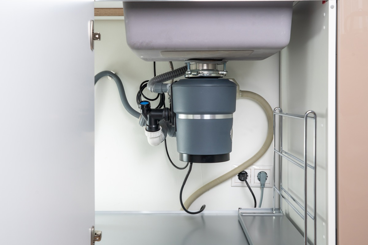 New garbage disposal installed beneath a kitchen sink
